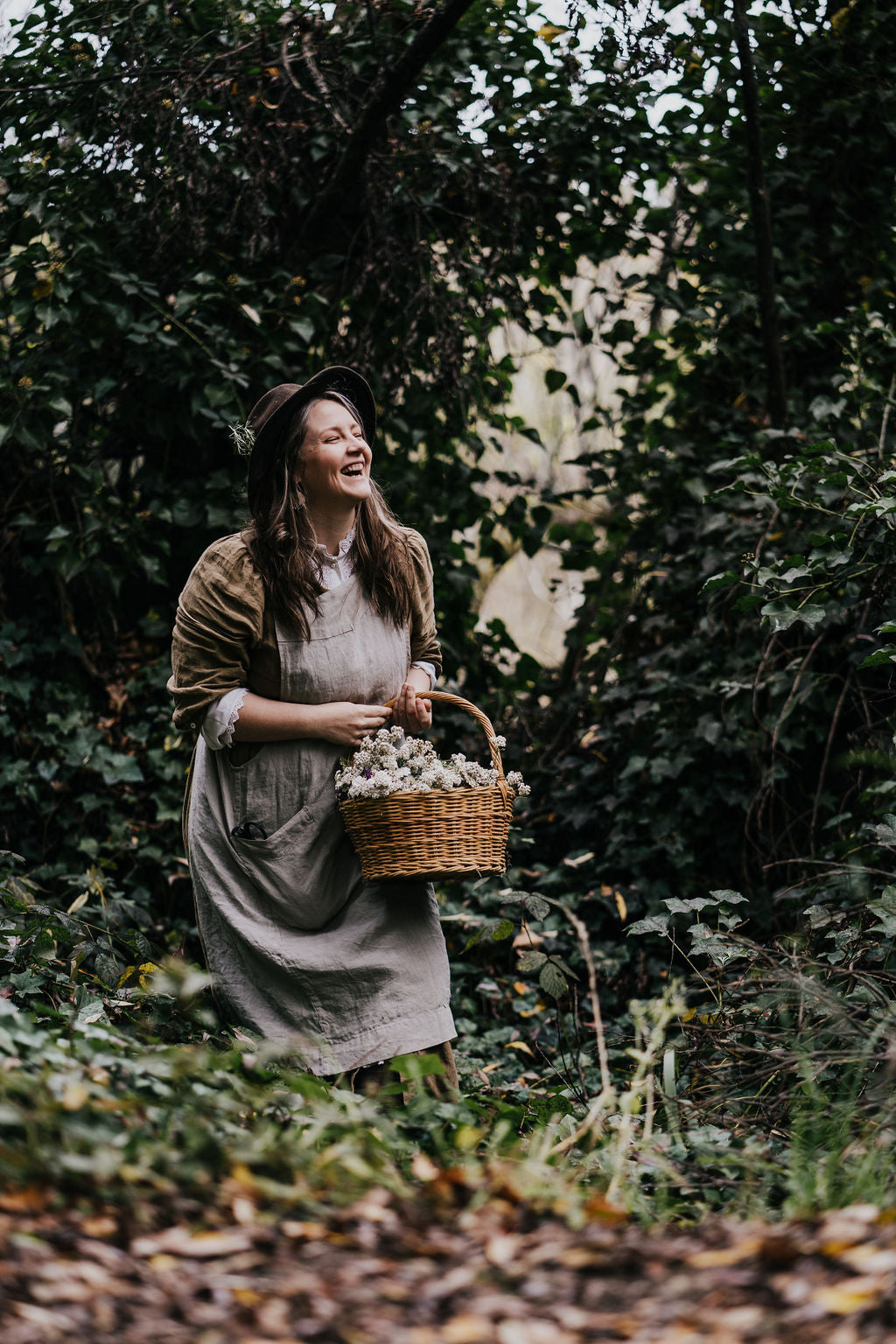 Woman laughing with basket of herbs