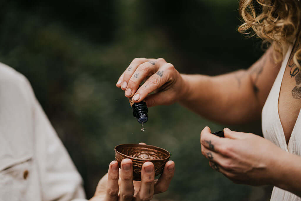 Essential oil being dripped into a copper cup