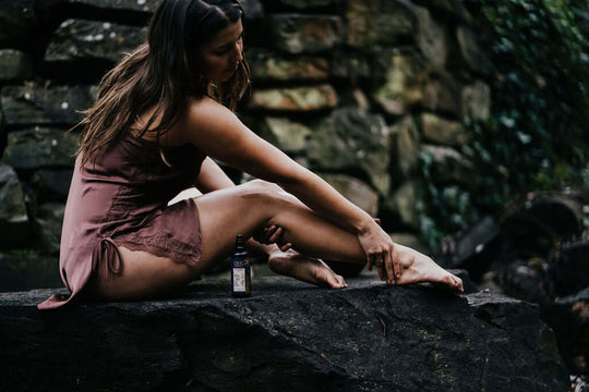 woman rubbing organic body massage oil onto her legs