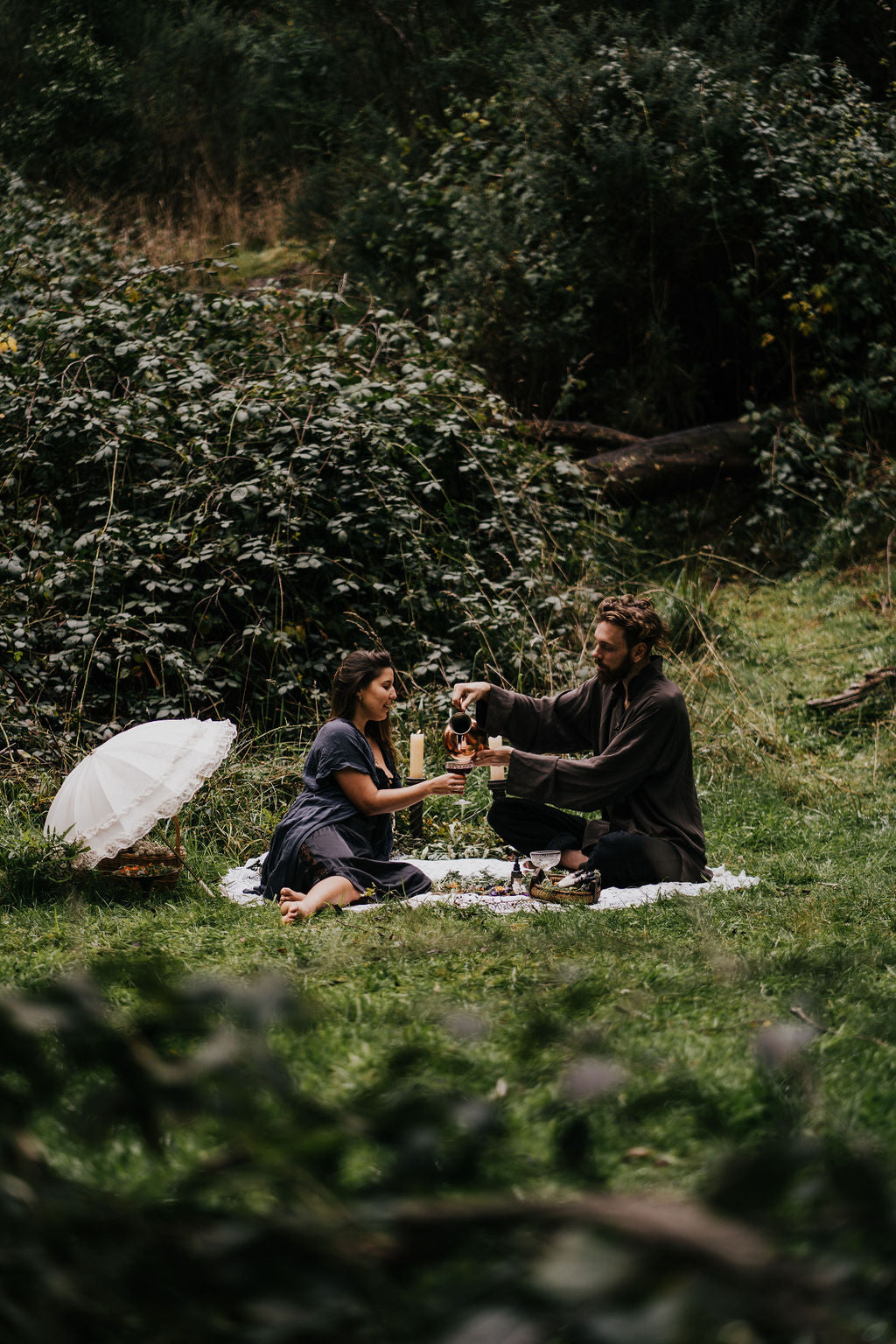 Couple in the forest with wine and tinctures