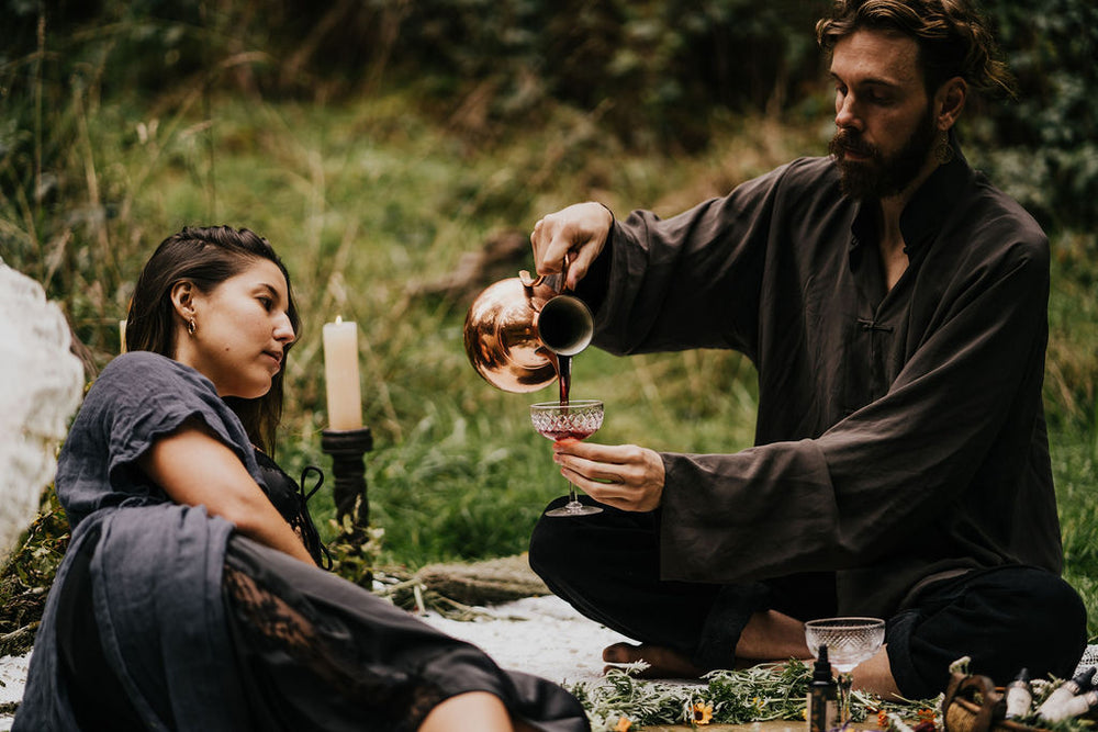 Couple in the forest with wine and tinctures