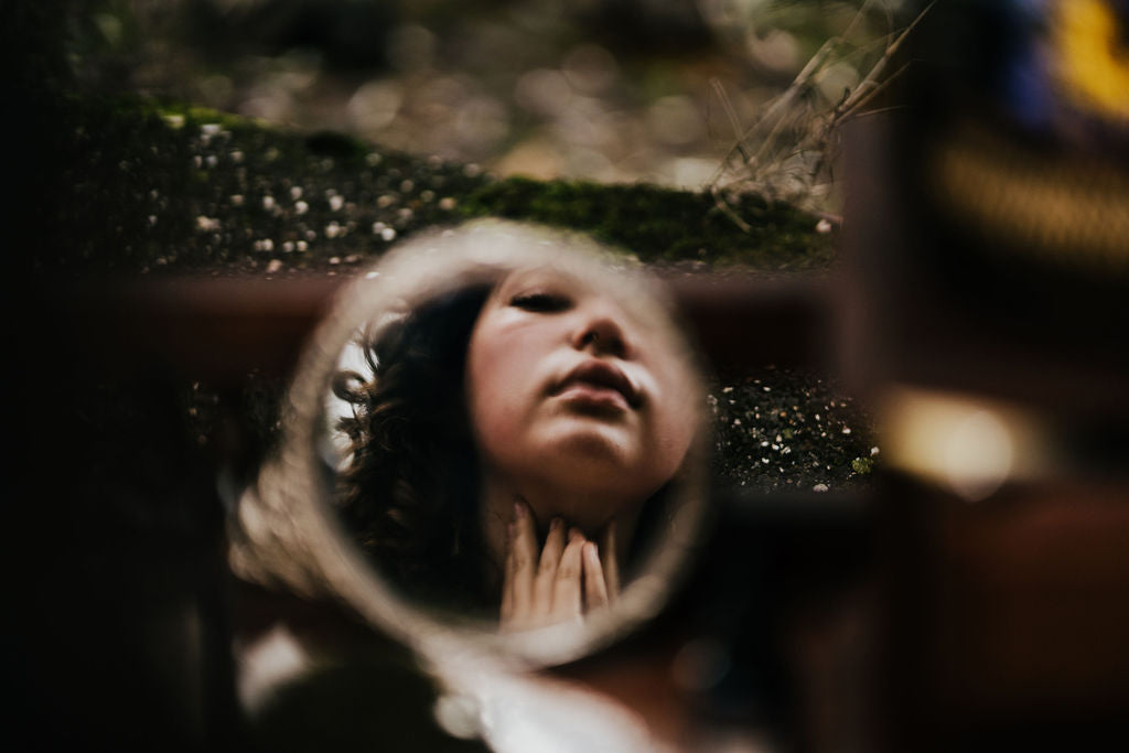 young womans face reflected in a mirror